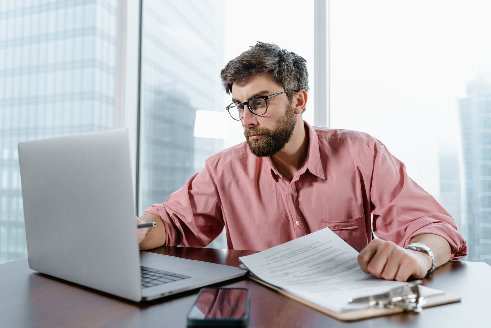 Bureau ouvert avec postes de travail et écrans affichant des données d'entreprise